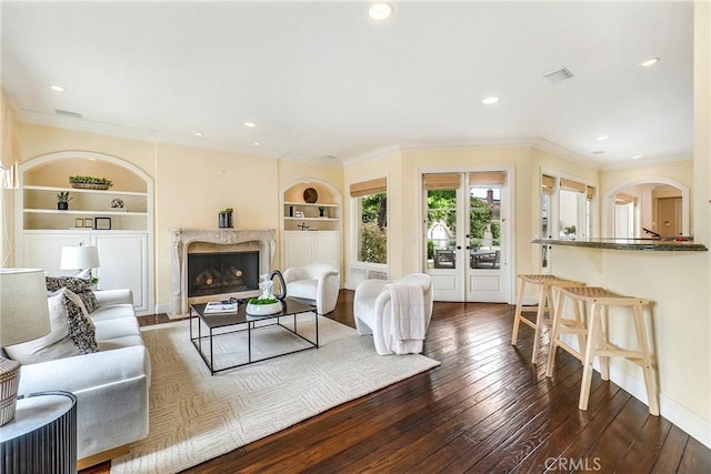 129 Via Waziers, Newport Beach, CA 92663 - living room with built in shelves, crown molding, hardwood / wood-style floors, a high end fireplace, and recessed lighting