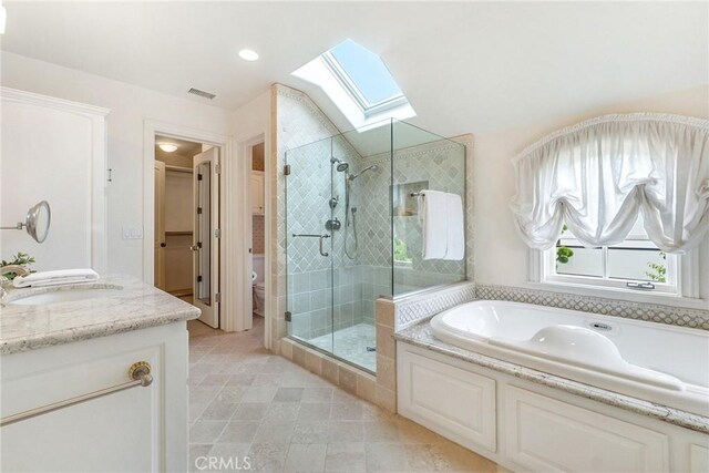 129 Via Waziers, Newport Beach, CA 92663 - bathroom featuring a skylight, a stall shower, a bath, vanity, and toilet