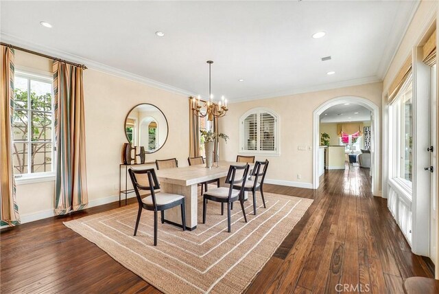 129 Via Waziers, Newport Beach, CA 92663 - dining space with dark wood-style floors, arched walkways, a chandelier, baseboards, and ornamental molding