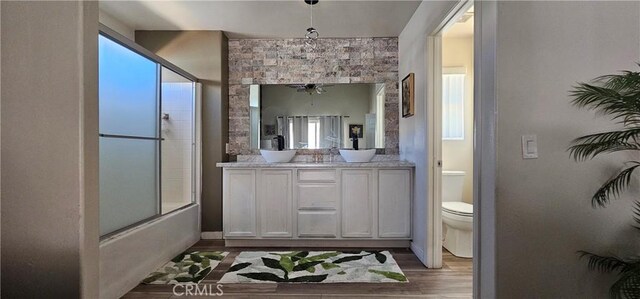 15781 Coral St, Palm Springs, CA 92262 - full bathroom featuring vanity, wood finished floors, enclosed tub / shower combo, and plenty of natural light