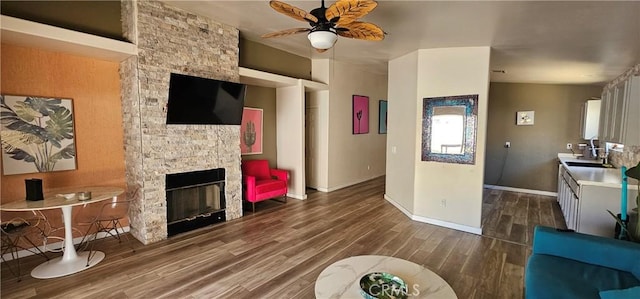 15781 Coral St, Palm Springs, CA 92262 - living area with dark wood-type flooring, ceiling fan, and a fireplace