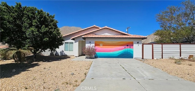 15781 Coral St, Palm Springs, CA 92262 - view of front of house featuring concrete driveway, a tile roof, a garage, and stucco siding