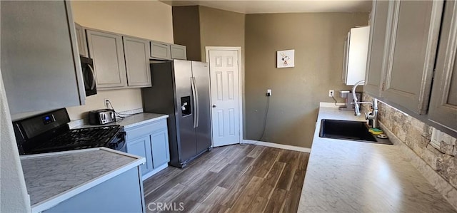 15781 Coral St, Palm Springs, CA 92262 - kitchen featuring black range with gas stovetop, stainless steel fridge, dark wood finished floors, light countertops, and water heater