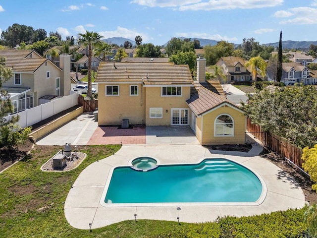 back of house with a residential view, a fenced backyard, a tile roof, and a patio area