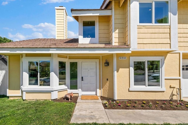 view of front of house featuring a chimney and stucco siding