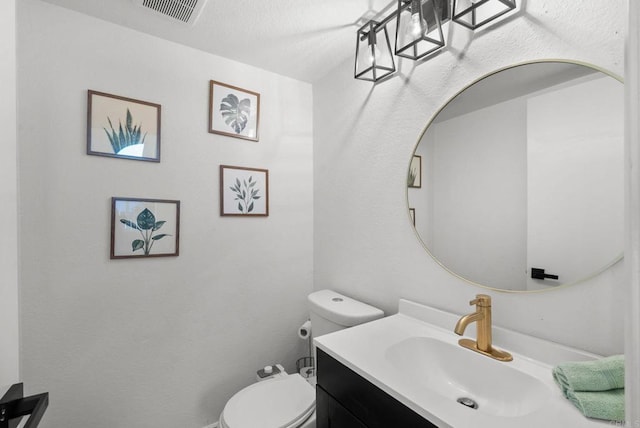 bathroom with visible vents, toilet, and vanity