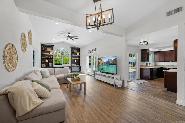 living room featuring visible vents, built in features, a wealth of natural light, and lofted ceiling