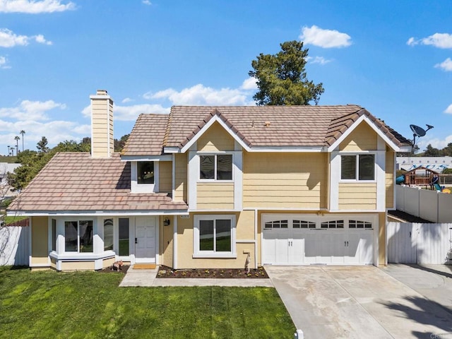 view of front facade with fence, an attached garage, a front lawn, a chimney, and driveway