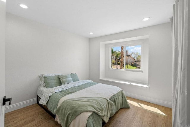 bedroom featuring baseboards, recessed lighting, and wood finished floors