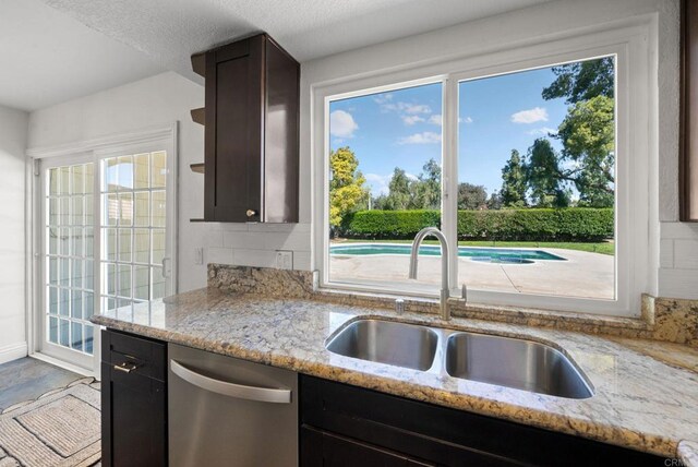 41910 Humber Dr, Temecula, CA 92591 - kitchen featuring stainless steel dishwasher, tasteful backsplash, light stone countertops, and dark brown cabinetry
