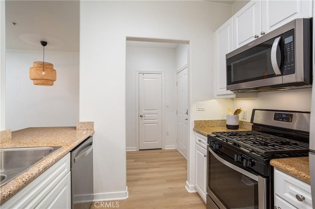 kitchen featuring white cabinets, appliances with stainless steel finishes, and light wood-type flooring