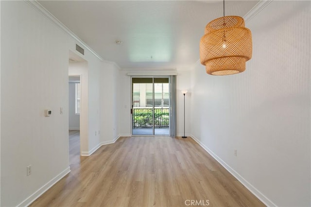 empty room featuring baseboards, visible vents, crown molding, and light wood-style flooring