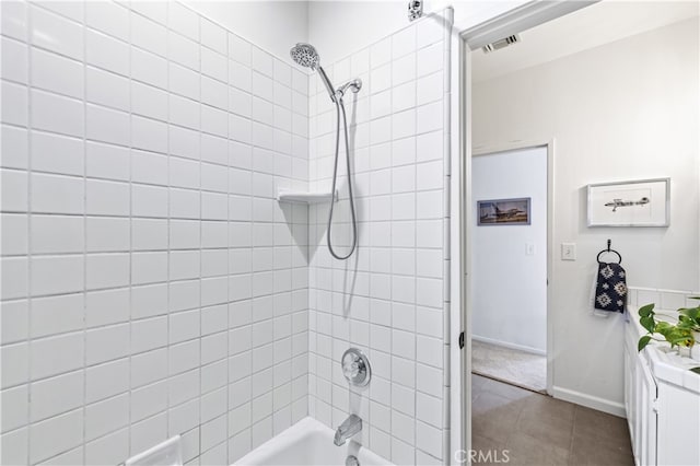bathroom with visible vents, baseboards, tile patterned flooring, and washtub / shower combination