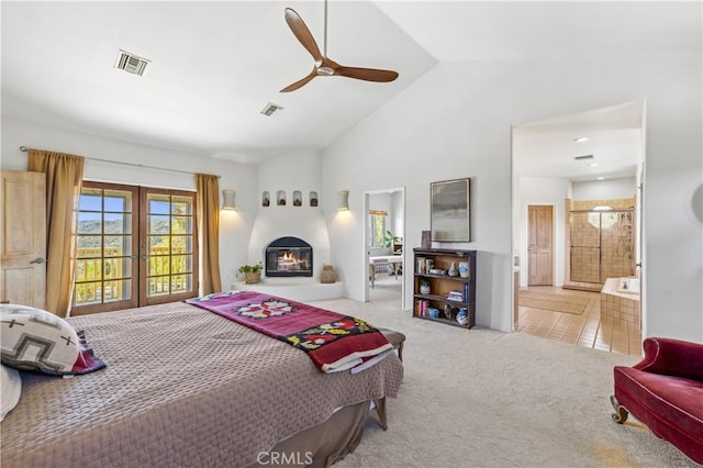 carpeted bedroom with visible vents, high vaulted ceiling, connected bathroom, and a fireplace