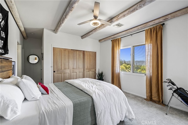 bedroom featuring a closet, light carpet, visible vents, beam ceiling, and ceiling fan