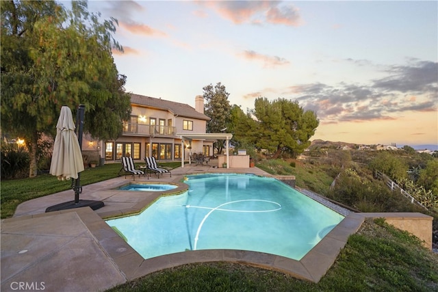 pool featuring a patio and an in ground hot tub