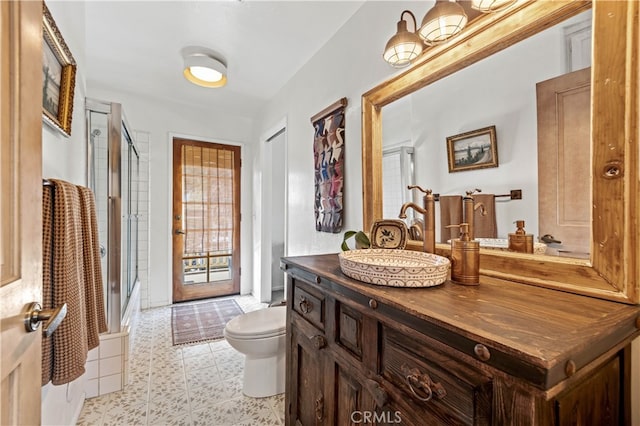 full bathroom with tile patterned floors, toilet, vanity, and a shower with shower door