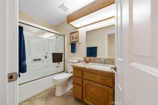 bathroom with vanity, visible vents, tile patterned flooring, toilet, and combined bath / shower with glass door