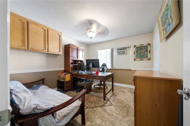 office space featuring a textured ceiling, a wall unit AC, baseboards, and ceiling fan