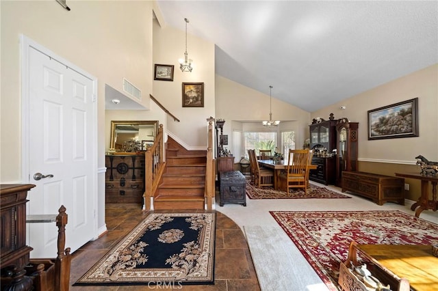 entrance foyer with a chandelier, visible vents, high vaulted ceiling, and stairs