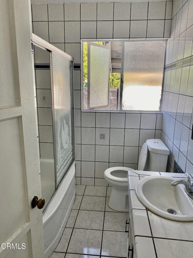 full bathroom with vanity, a wealth of natural light, toilet, and shower / bath combination with glass door