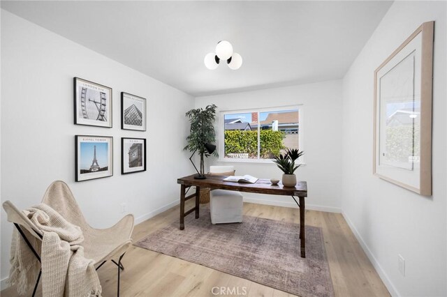 office space with baseboards and light wood-style floors