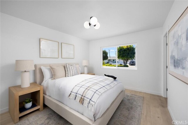 bedroom featuring baseboards and light wood finished floors