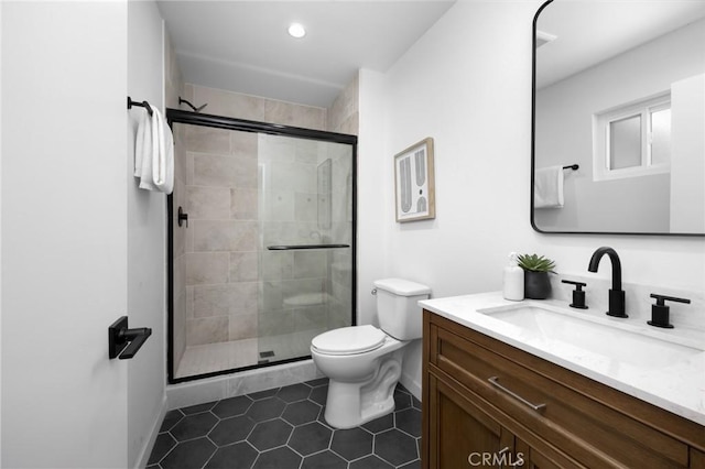 bathroom with vanity, toilet, tile patterned floors, and a stall shower