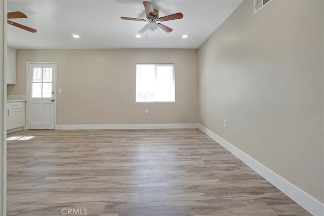 spare room featuring recessed lighting, baseboards, light wood-type flooring, and a ceiling fan