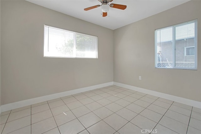 spare room with baseboards, a healthy amount of sunlight, and a ceiling fan