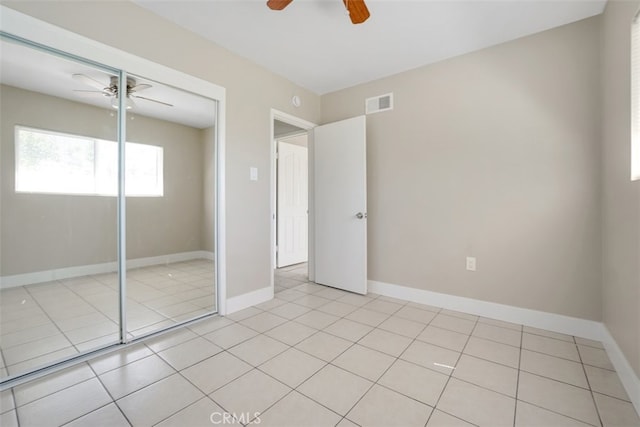 unfurnished bedroom featuring visible vents, ceiling fan, baseboards, light tile patterned flooring, and a closet
