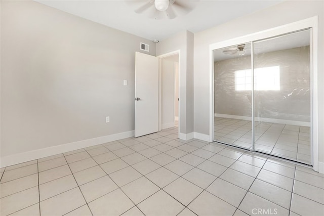 unfurnished bedroom featuring light tile patterned flooring, visible vents, baseboards, and ceiling fan
