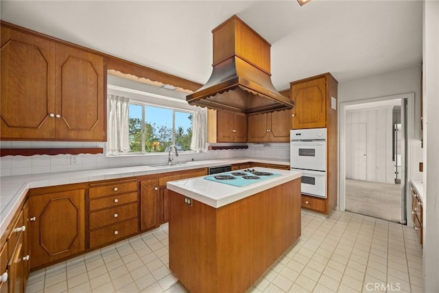 kitchen featuring a sink, a center island, white appliances, brown cabinetry, and decorative backsplash