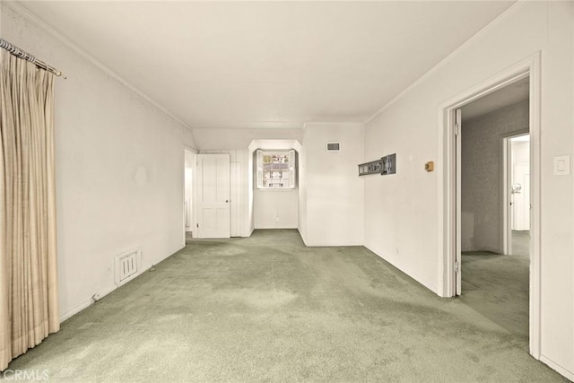 unfurnished room with crown molding, carpet, and visible vents