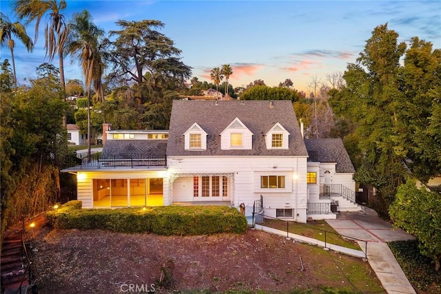 back of house featuring a shingled roof