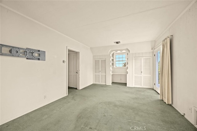 unfurnished room featuring visible vents, ornamental molding, and carpet floors