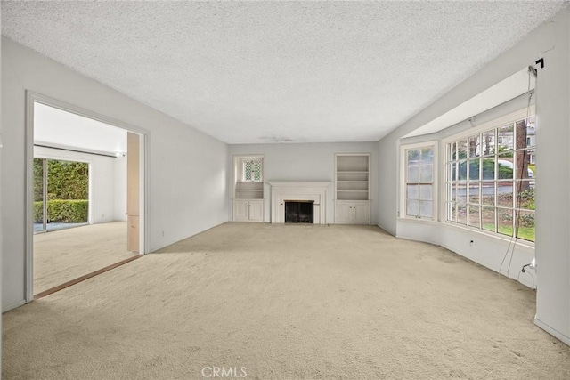 unfurnished living room with a fireplace, a textured ceiling, and carpet