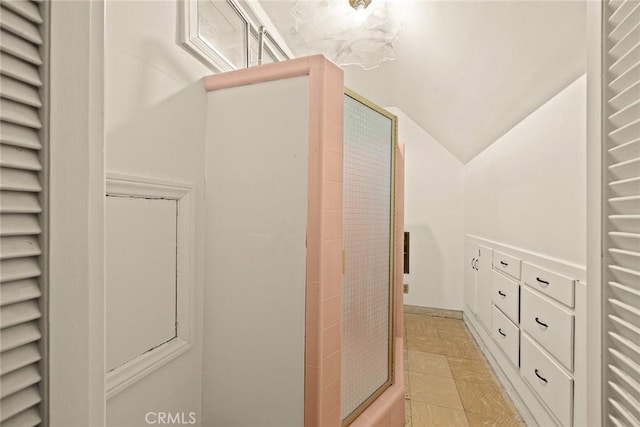 bathroom featuring tiled shower and vaulted ceiling