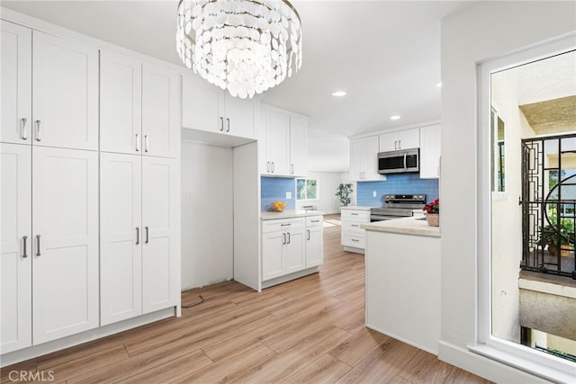 2392 Via Mariposa W Unit 3D, Laguna Woods, CA 92637 - kitchen featuring stainless steel appliances, white cabinetry, decorative backsplash, light wood finished floors, and recessed lighting
