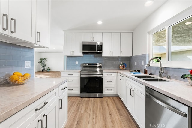 2392 Via Mariposa W Unit 3D, Laguna Woods, CA 92637 - kitchen with appliances with stainless steel finishes, a sink, backsplash, light wood-style flooring, and recessed lighting