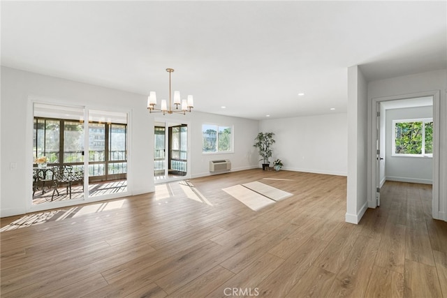 2392 Via Mariposa W Unit 3D, Laguna Woods, CA 92637 - unfurnished living room with a chandelier, plenty of natural light, light wood-type flooring, a wall unit AC, and recessed lighting