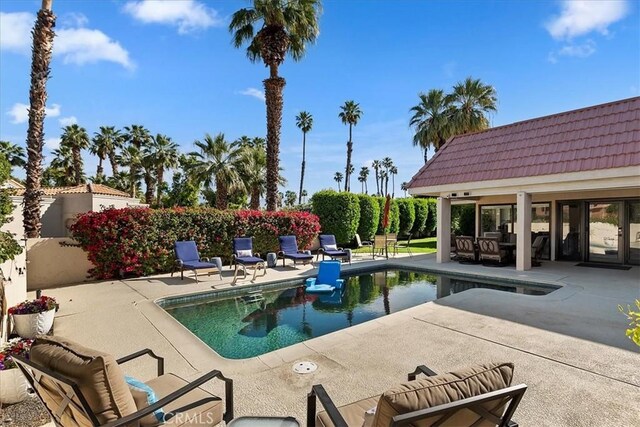 view of swimming pool with an outdoor structure, a fenced in pool, fence, and a patio