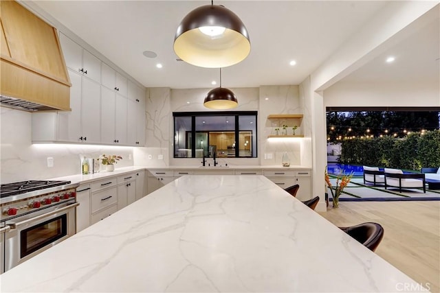 4949 Petit Ave, Encino, CA 91436 - kitchen featuring light stone countertops, a sink, custom range hood, high end stainless steel range, and white cabinetry