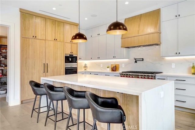 4949 Petit Ave, Encino, CA 91436 - kitchen featuring a breakfast bar, custom exhaust hood, appliances with stainless steel finishes, tasteful backsplash, and a center island