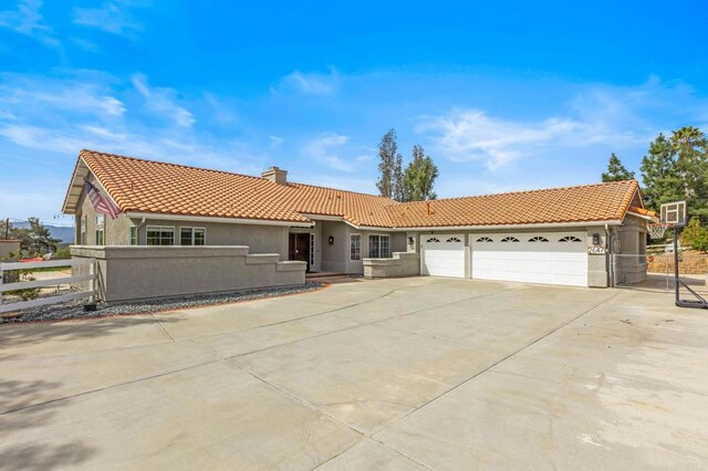 single story home with a tile roof, stucco siding, fence, and a garage