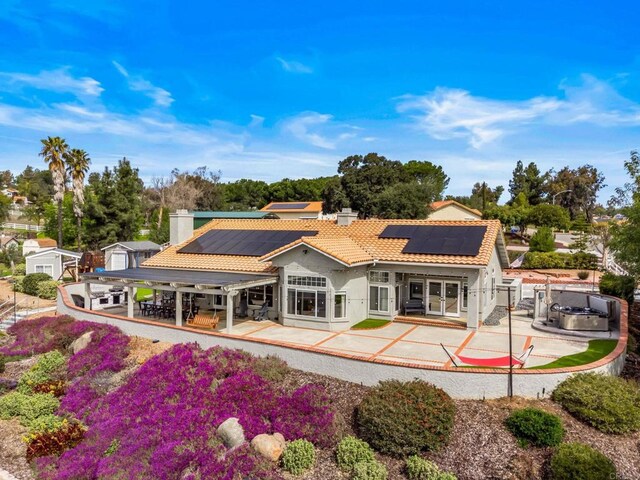 back of house with a chimney, a tiled roof, french doors, and a patio