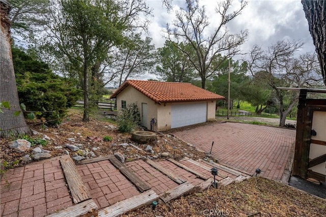 13155 San Antonio Rd, Atascadero, CA 93422 - view of side of property featuring stucco siding, a detached garage, a tiled roof, fence, and an outdoor structure
