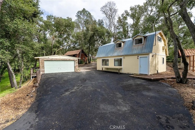 13155 San Antonio Rd, Atascadero, CA 93422 - view of front of home with metal roof, an outdoor structure, a gambrel roof, a garage, and view of wooded area
