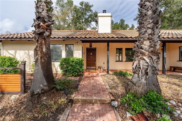 13155 San Antonio Rd, Atascadero, CA 93422 - mediterranean / spanish house featuring a chimney, stucco siding, a tile roof, and covered porch