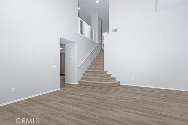 interior space with visible vents, stairs, baseboards, and wood finished floors